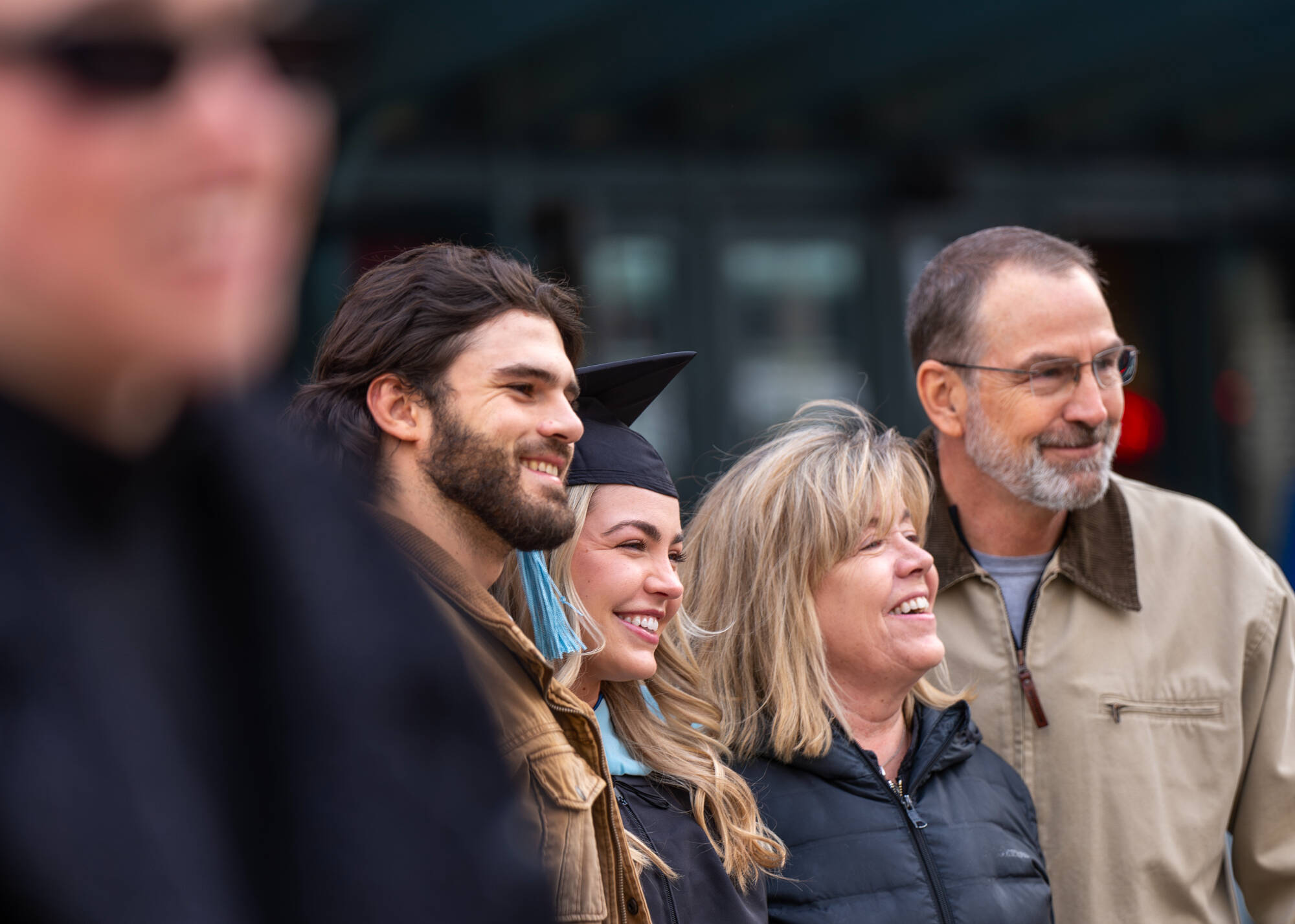A soon-to-be graduate poses with their family before the Commencement ceremony at Van Andel Arena December 7.